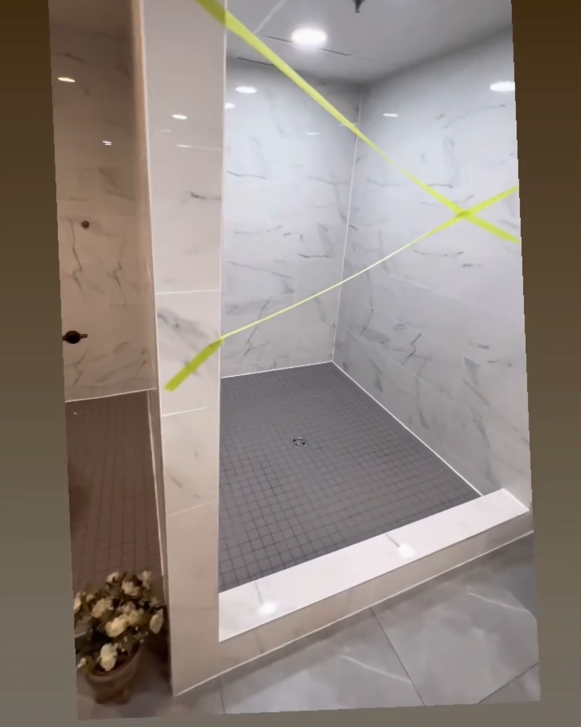 An alternate view of the marble-look surround shows the raised threshold and small-format floor tile. Shown in progress.