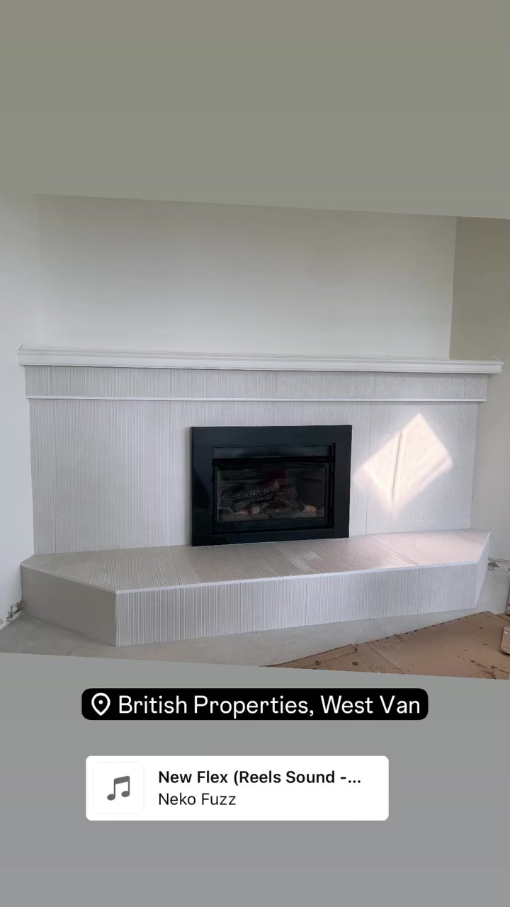 Light tile wraps a broad fireplace surround and raised hearth, keeping the finish quiet and architectural.